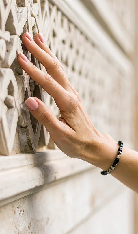 Une main touchant un mur dans une maison de caractère